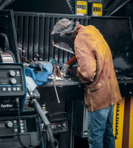 a photo of a student working on welding equipment