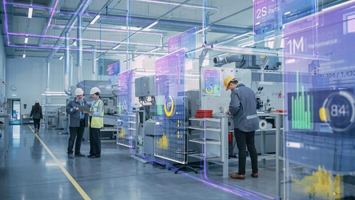 Workers wearing hard hats stand inside a factory. Data is displayed on augmented-reality screens.